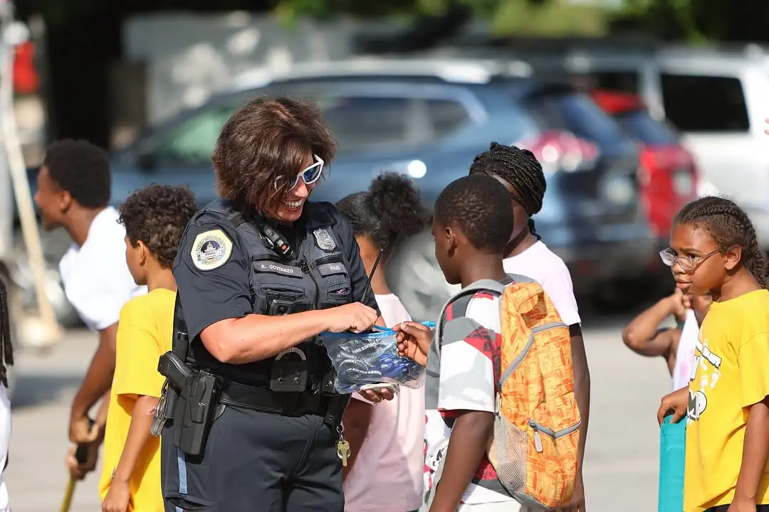 Des Moines Police officer shares a friendly moment with neighborhood children during National Night Out