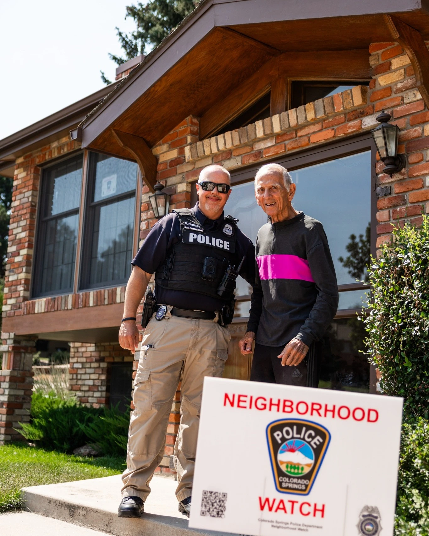 Colorado Springs Police officer stands with Joe Joseph, Neighborhood Watch Block Captain since 1994
