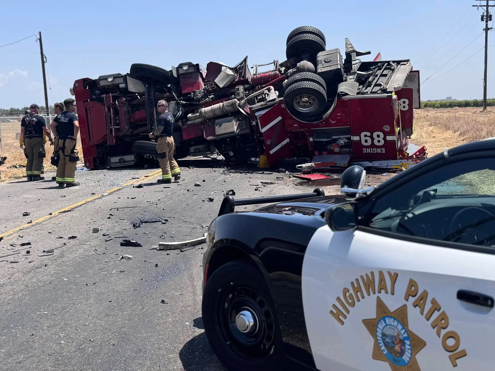 Overturned fire truck Engine 68 with emergency responders at crash scene